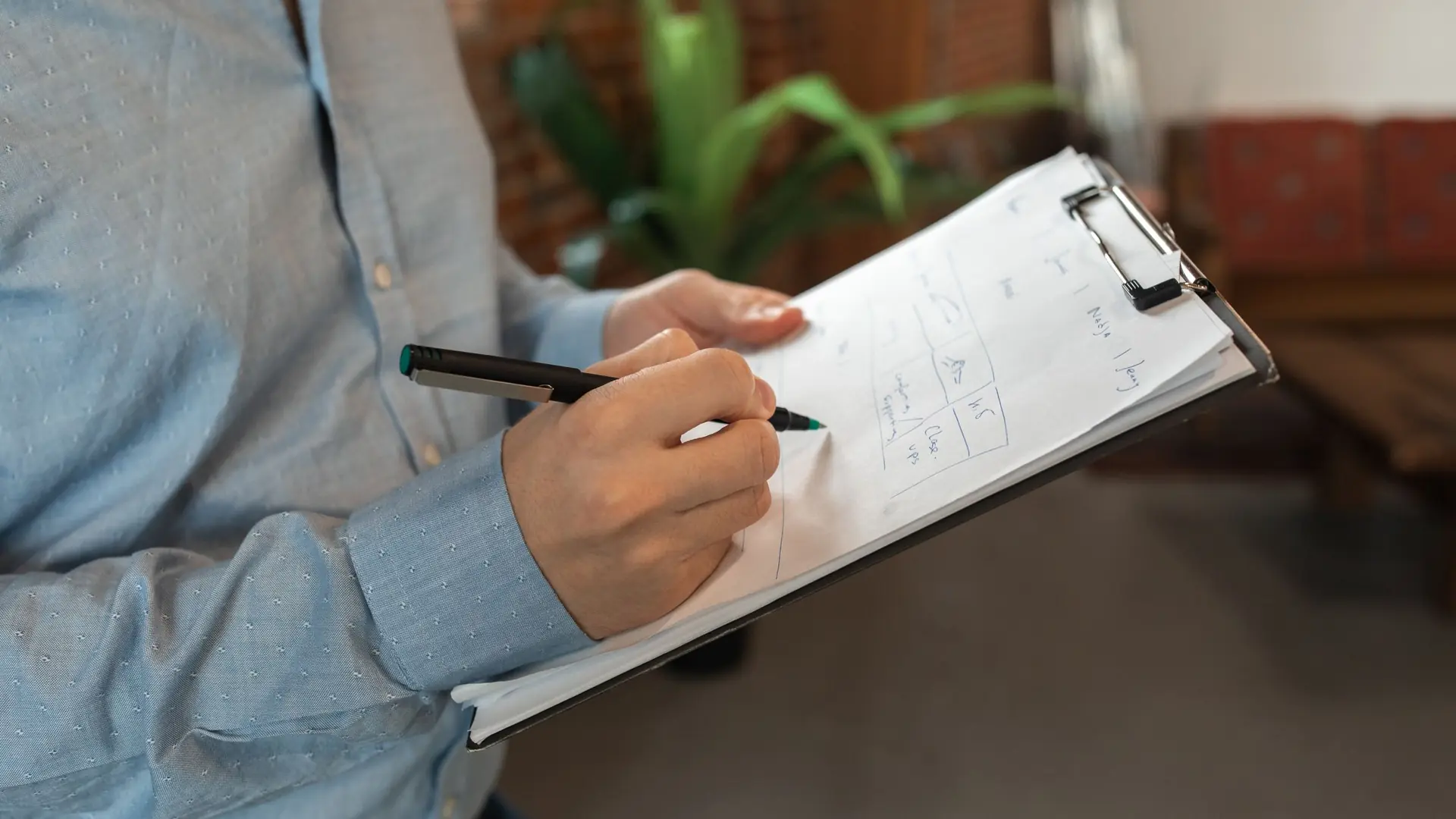 A hand ticking items on a clipboard checklist